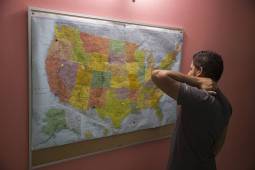 guy looking at map of united states on wall